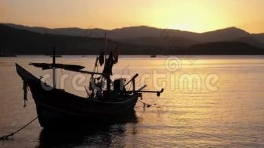 船靠近岸，映衬着山峦和美丽的夕阳.. 浪漫的气氛。 镇静和安抚